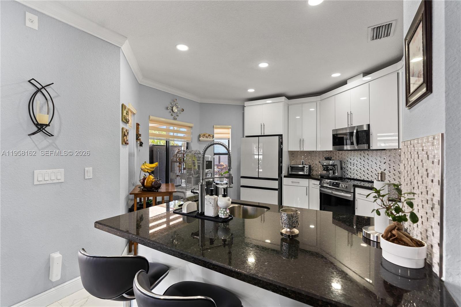 3281 Southwest 145th Avenue Miami, FL 33175 - Photo 11 of 56 a kitchen with a table and chairs in it