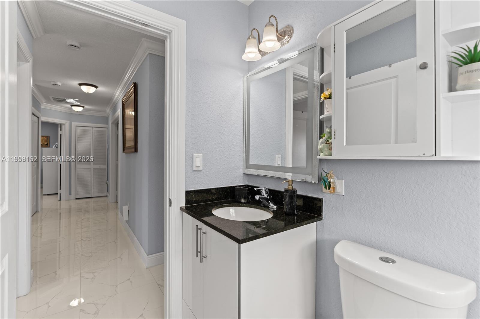 3281 Southwest 145th Avenue Miami, FL 33175 - Photo 52 of 56 a bathroom with a sink a toilet and a mirror