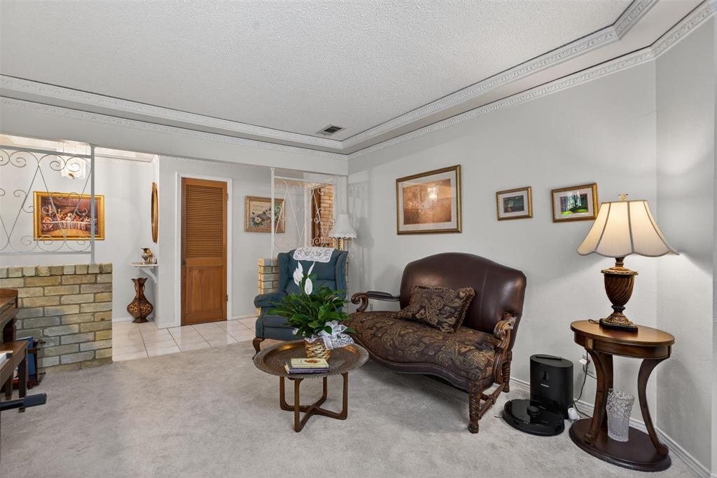 6010 Hunters View Lane Dallas, TX 75232 - Photo 5 of 28 Carpeted living area featuring decorative crown molding and white walls