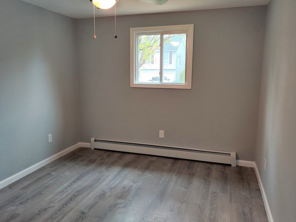 173 Wrentham Road Springfield, MA 01119 - Photo 11 of 15 an empty room with wooden floor and windows