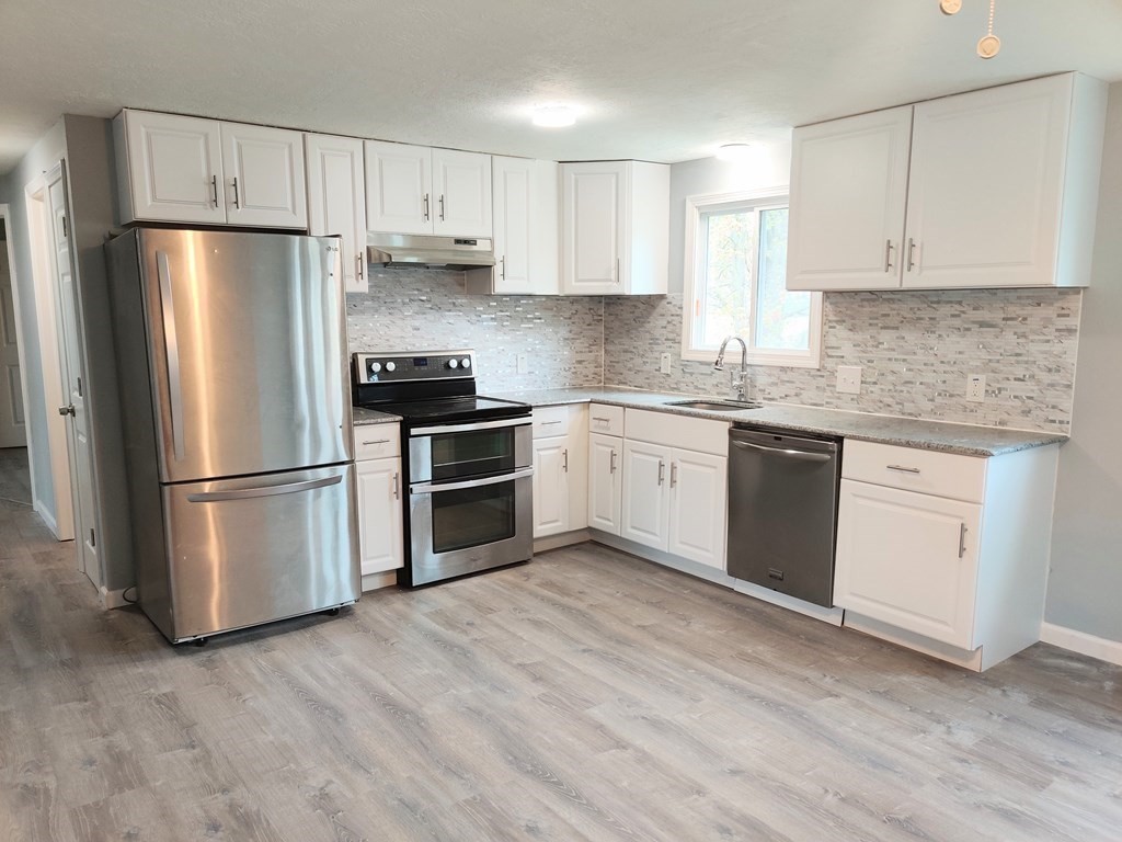 173 Wrentham Road Springfield, MA 01119 - Photo 3 of 15 a kitchen with stainless steel appliances granite countertop a refrigerator sink and white cabinets