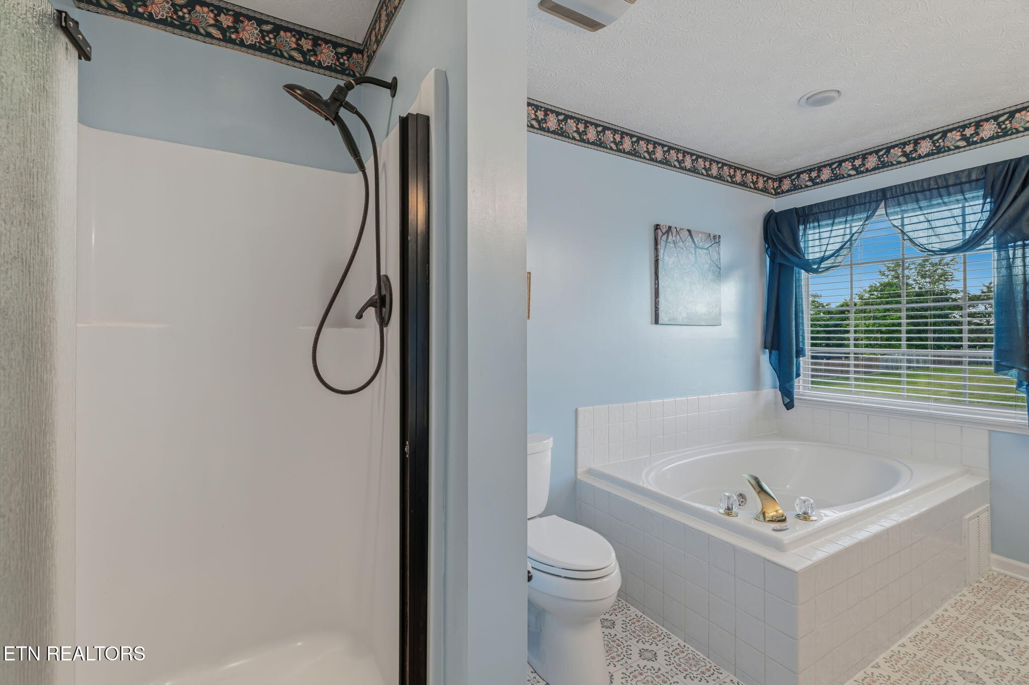 7030 Westerly Winds Road Knoxville, TN 37931 - Photo 26 of 40 a bathroom with a bath tub a sink and a shower