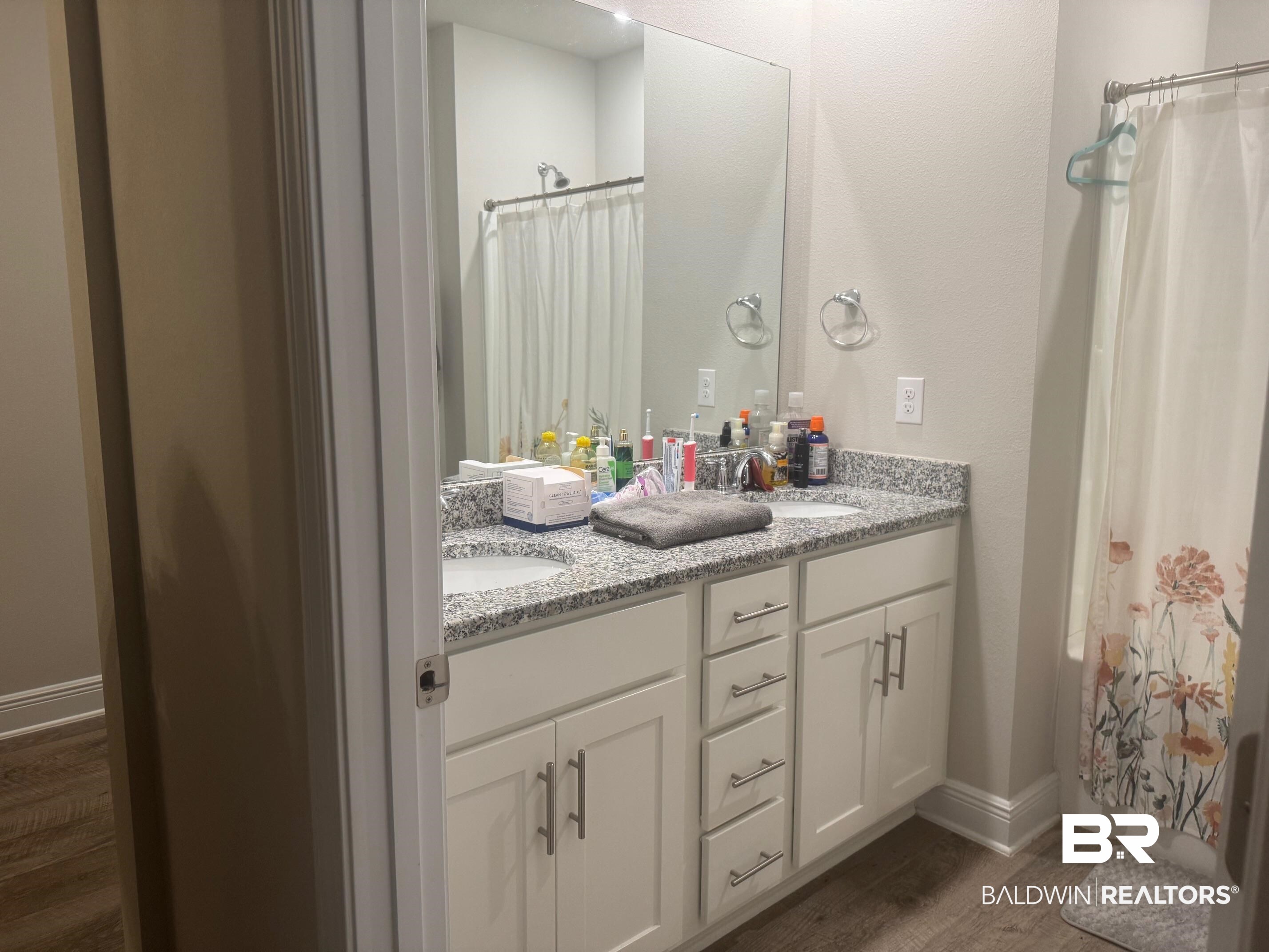 24903 Spectacular Bid Loop Daphne, AL 36526 - Photo 29 of 37 Full bath with wood finished floors, double vanity, and shower / bathtub combination with curtain