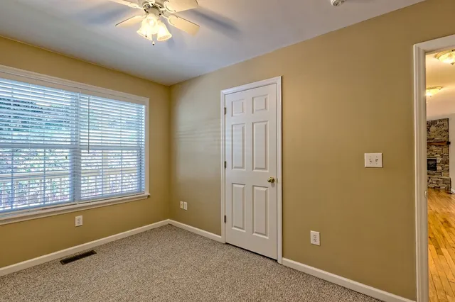 a view of an empty room with wooden floor and stairs