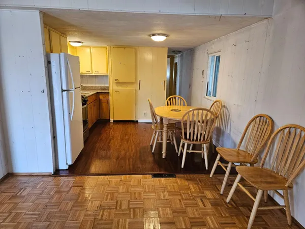a room with chairs and view of kitchen