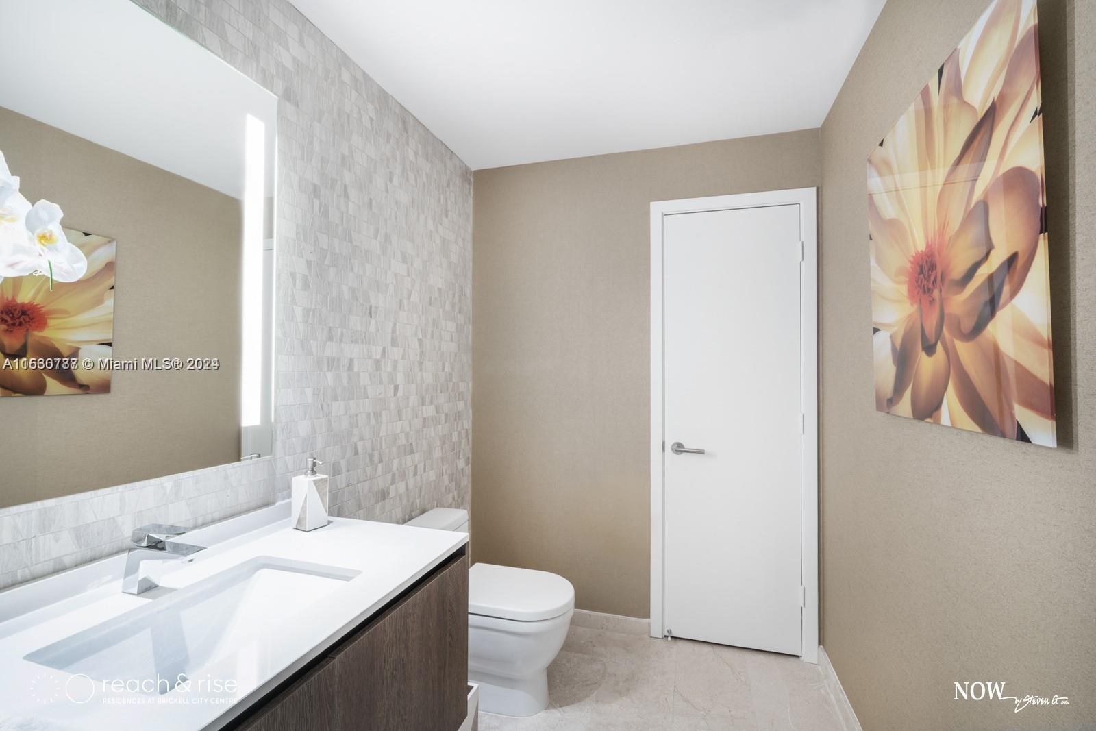 88 Southwest 7th Street, Unit 1403 Miami, FL 33130 - Photo 14 of 15 a bathroom with a sink a toilet and a mirror