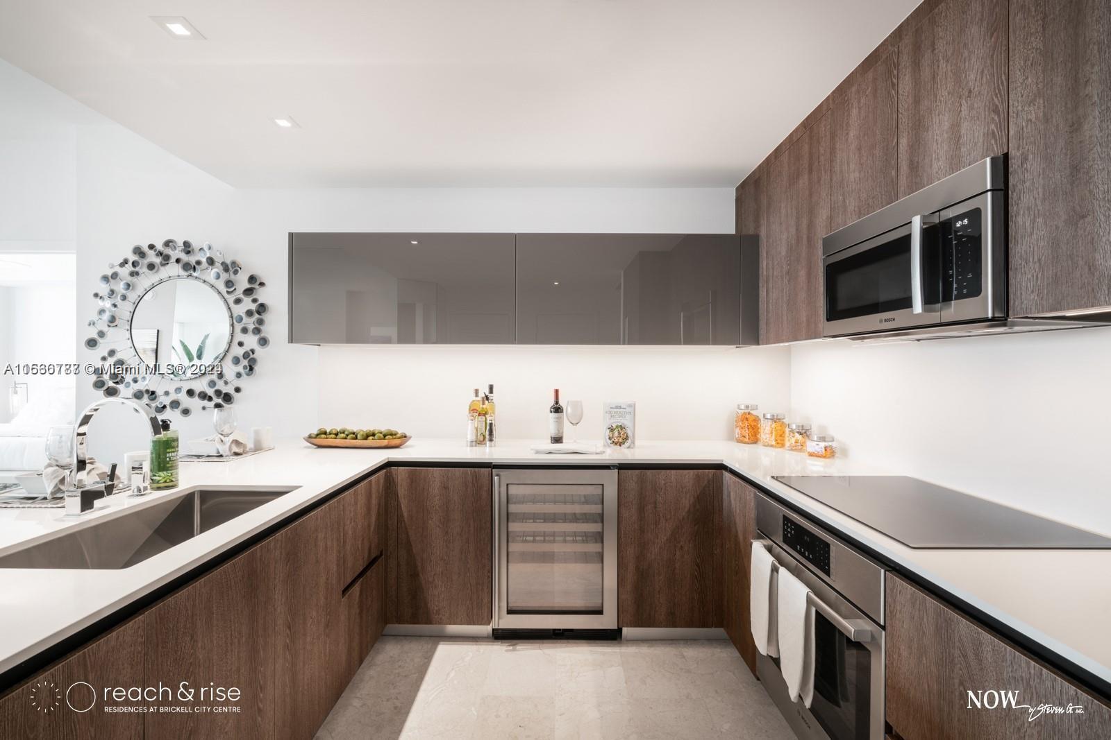 88 Southwest 7th Street, Unit 1403 Miami, FL 33130 - Photo 5 of 15 a kitchen with stainless steel appliances a sink dishwasher stove and microwave with wooden floor