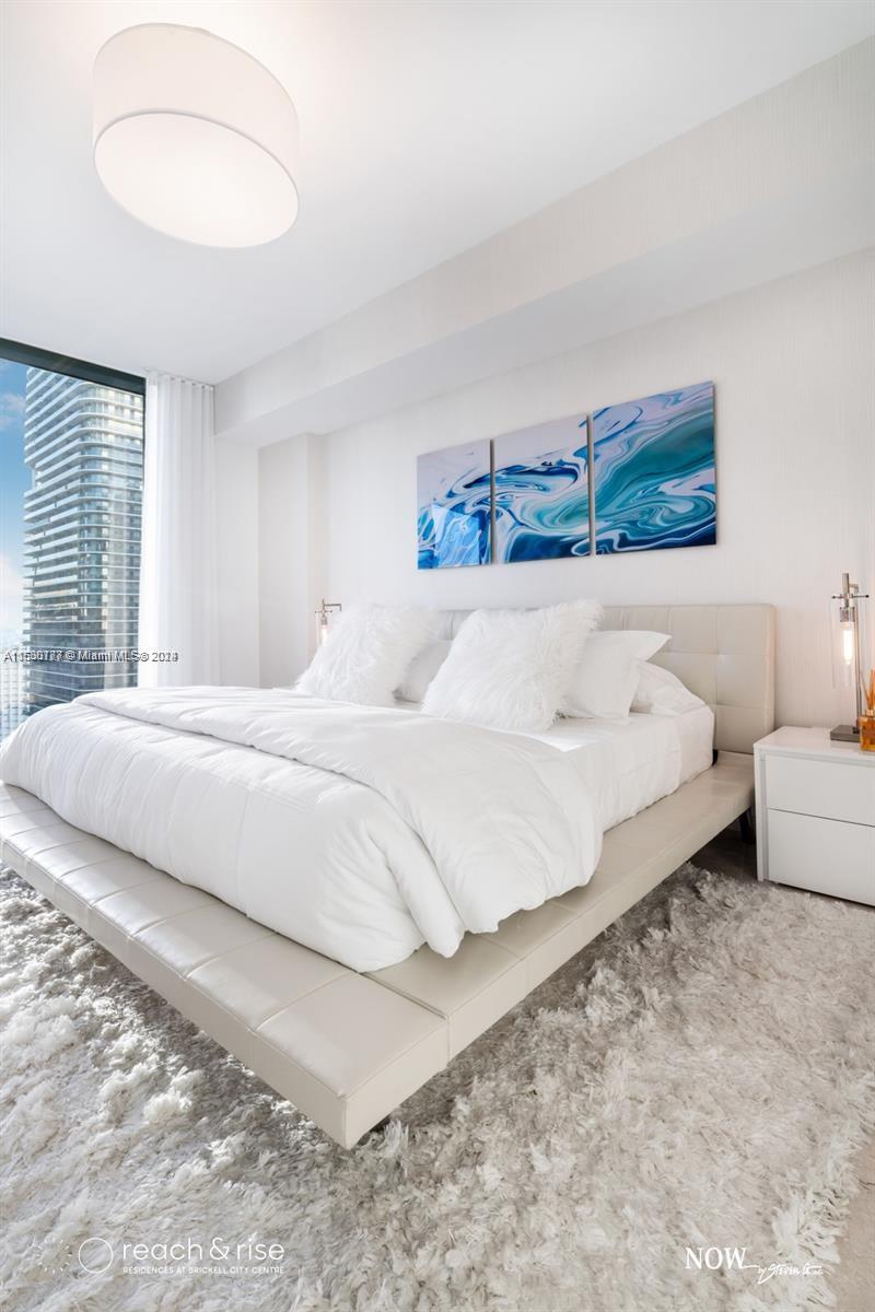 88 Southwest 7th Street, Unit 1403 Miami, FL 33130 - Photo 8 of 15 a spacious bedroom with a bed and a couch