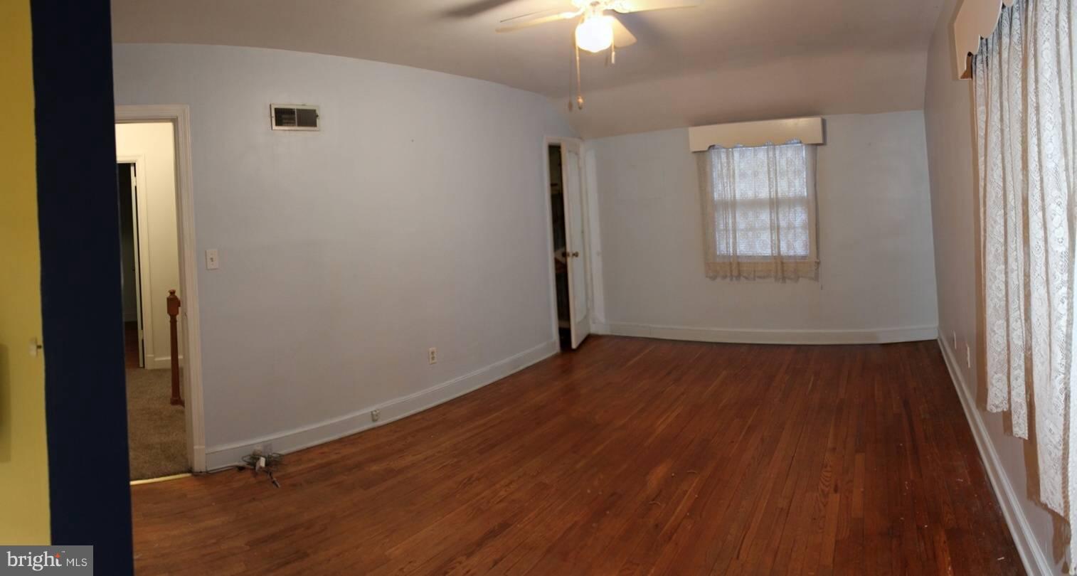 9009 Walden Road Silver Spring, MD 20901 - Photo 17 of 22 an empty room with wooden floor fan and windows