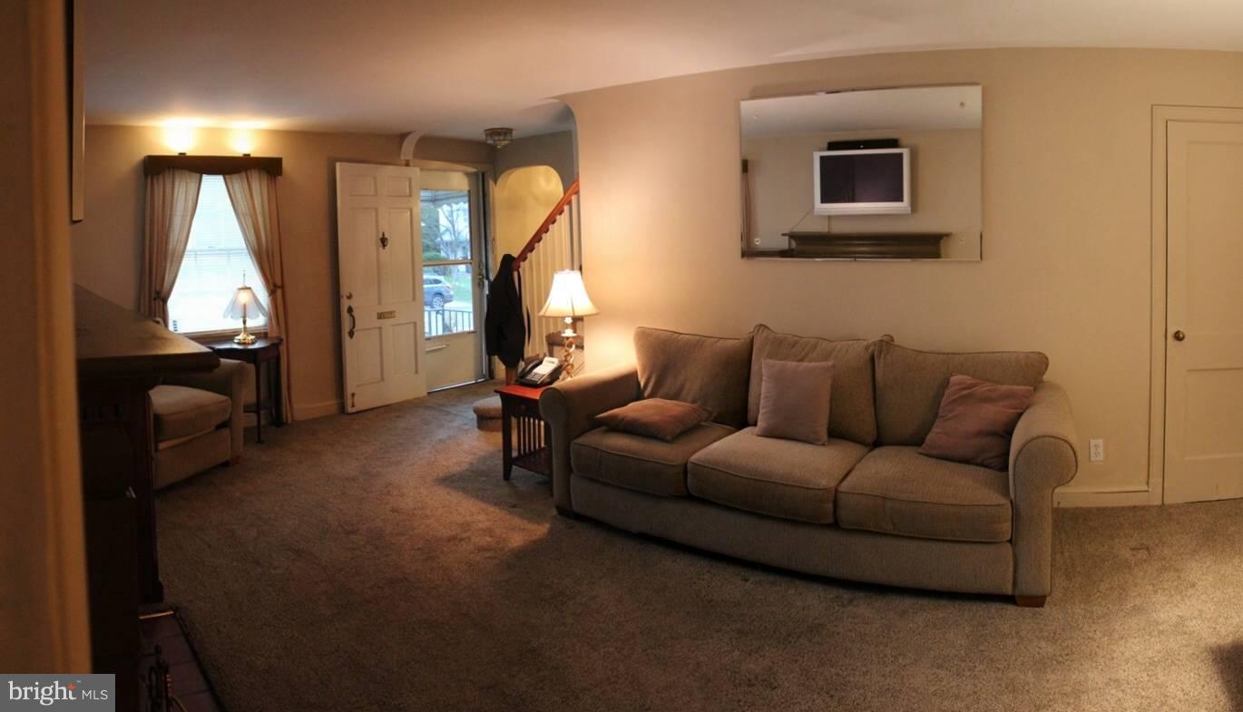 9009 Walden Road Silver Spring, MD 20901 - Photo 8 of 22 a living room with furniture a flat screen tv and a window