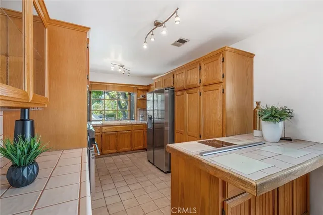 a kitchen with granite countertop a sink stainless steel appliances wooden floor and cabinets