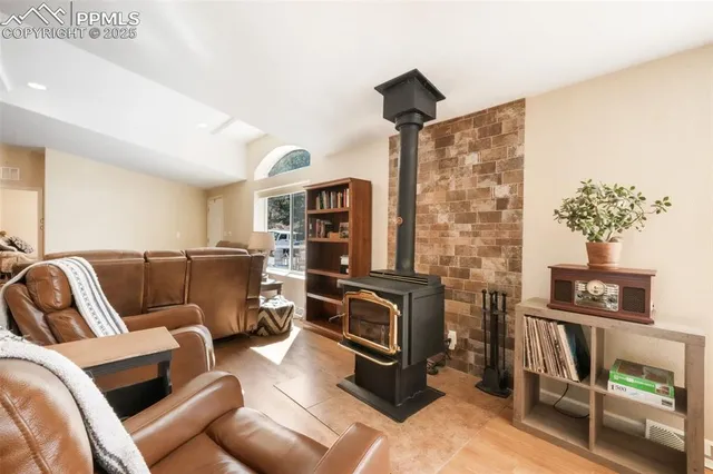 a living room with furniture floor to ceiling window and wooden floor