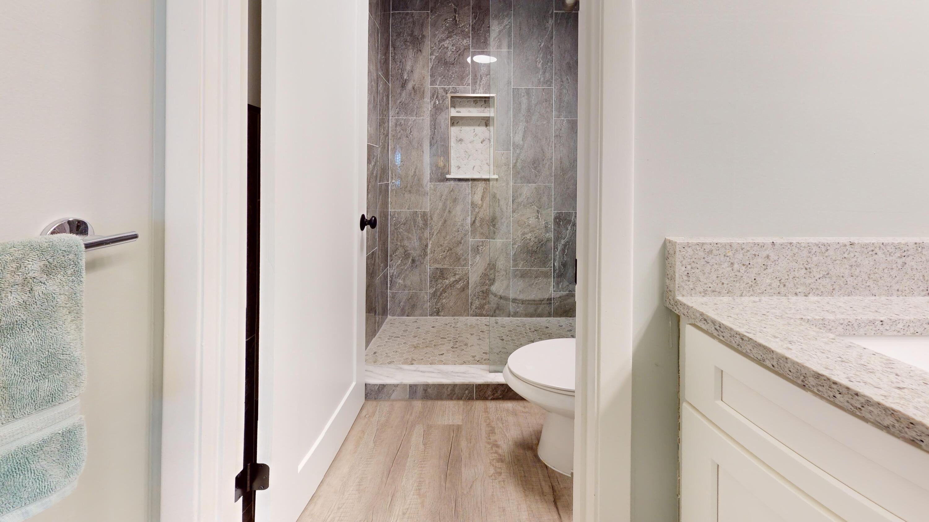 1856 Southwest Palm City Road, Unit 203 Stuart, FL 34994 - Photo 18 of 22 a bathroom with a granite countertop bathtub shower sink and toilet