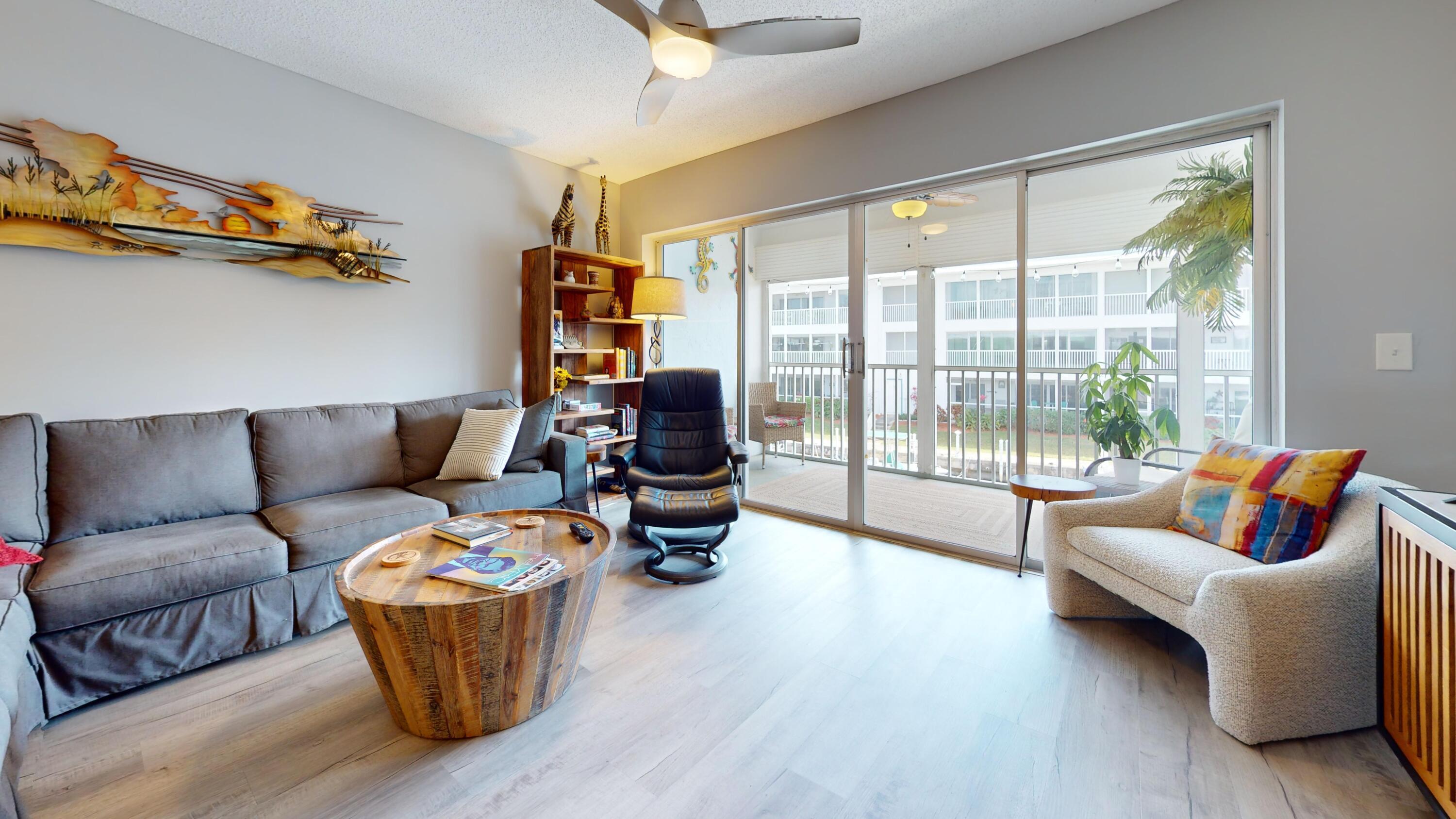 1856 Southwest Palm City Road, Unit 203 Stuart, FL 34994 - Photo 5 of 22 a living room with furniture and a floor to ceiling window