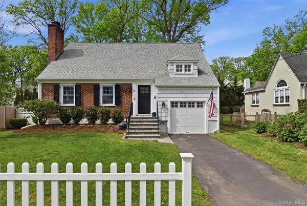 a front view of a house with a yard and green space