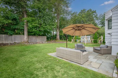 a view of a backyard with furniture and umbrella