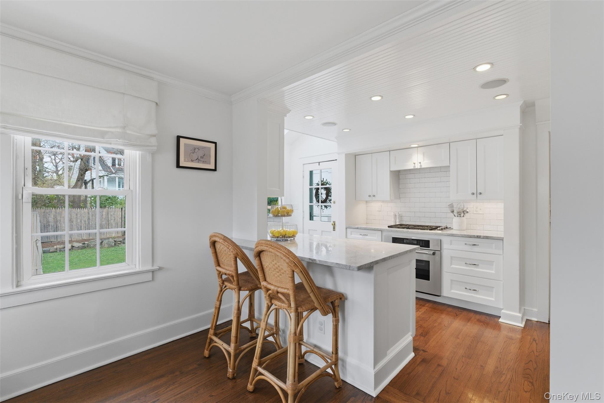 32 Kingsbury Road New Rochelle, NY 10804 - Photo 9 of 31 a kitchen with stainless steel appliances kitchen island granite countertop a stove a refrigerator a sink with white cabinets and wooden floor