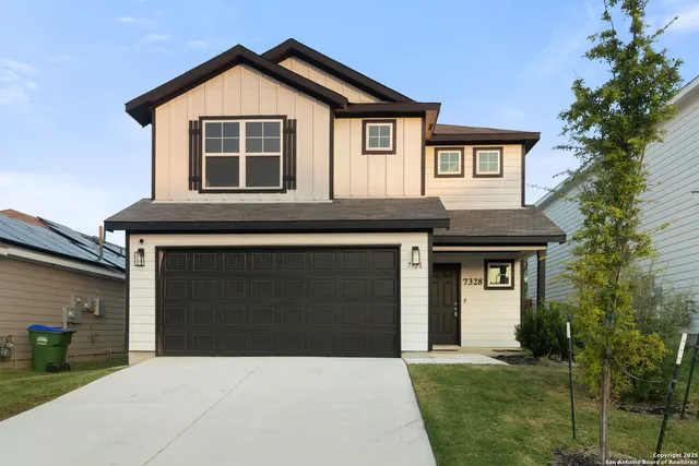 a front view of a house with a yard and garage
