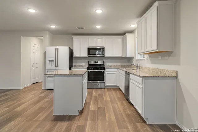 a kitchen with white cabinets and stainless steel appliances