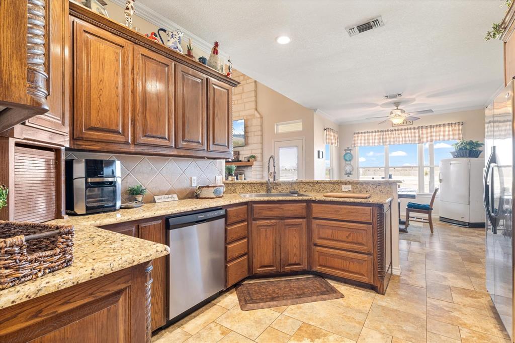 2885 Enloe Road Howe, TX 75459 - Photo 22 of 39 a kitchen with stainless steel appliances granite countertop a sink and cabinets