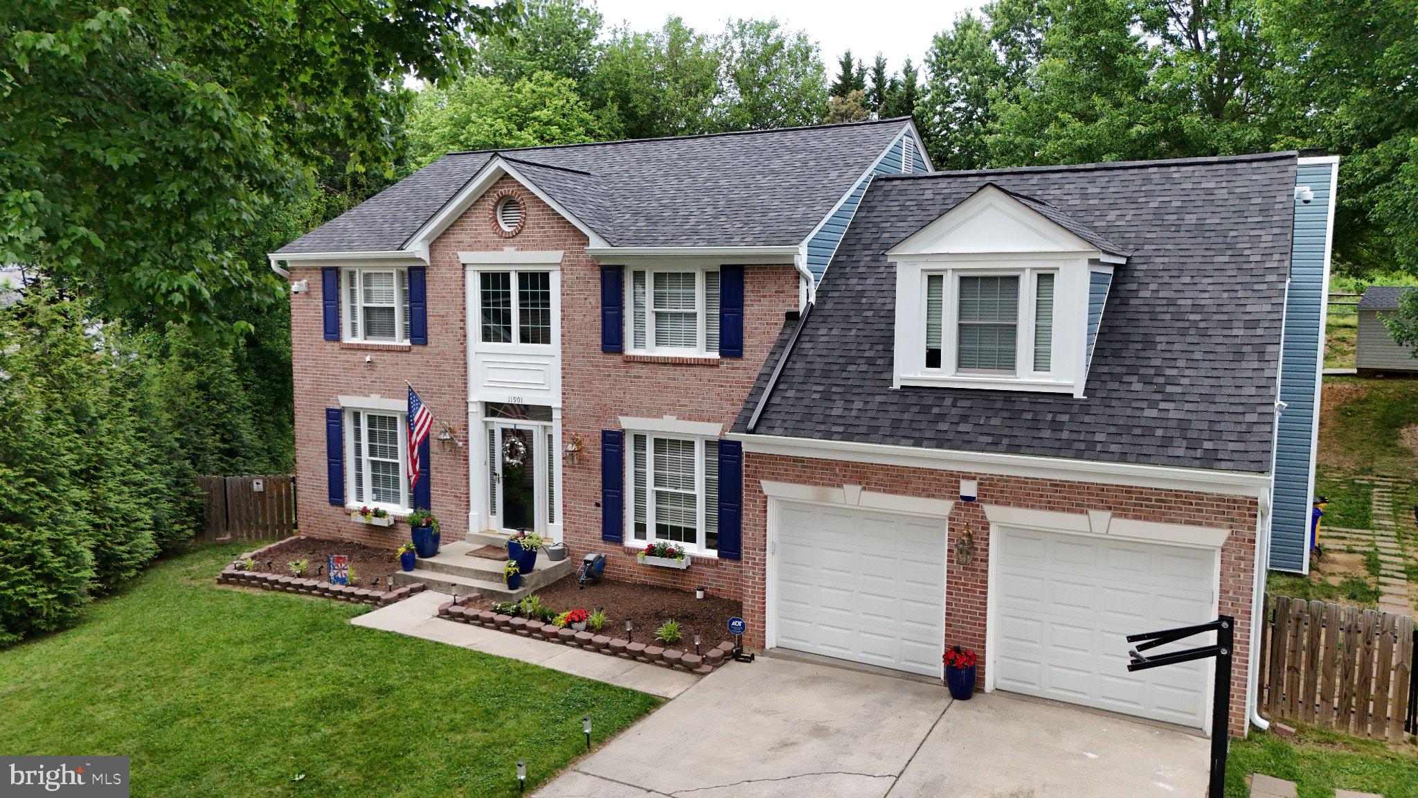 Charming brick home with lush greenery.
