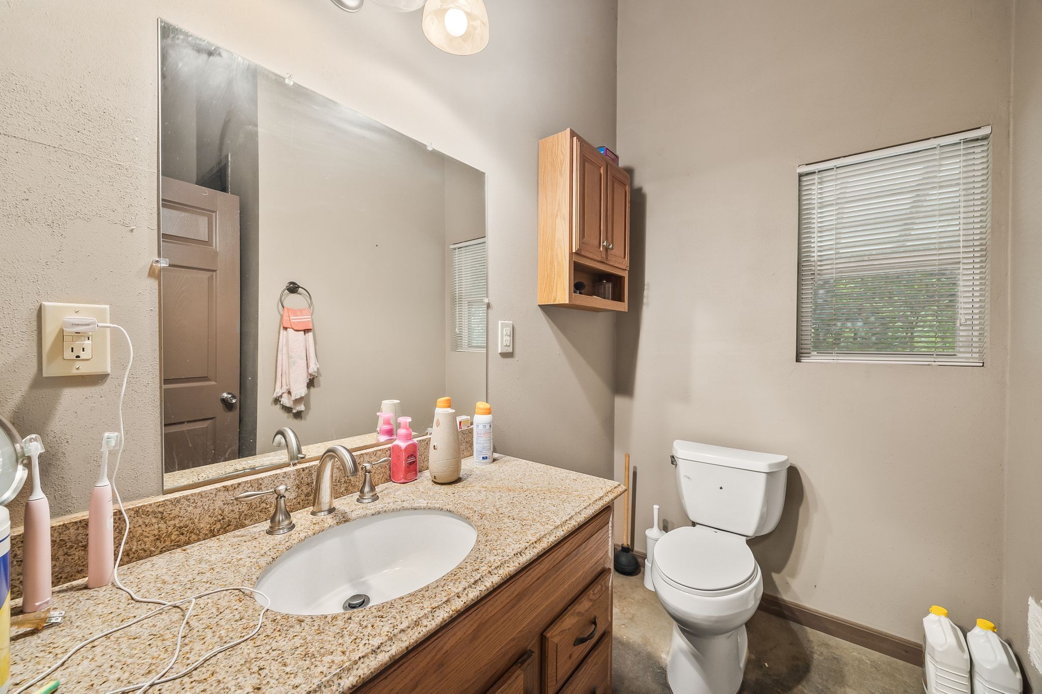 1582 Hellsneck Road Waverly, TN 37185 - Photo 13 of 72 a bathroom with a granite countertop toilet a sink and a mirror