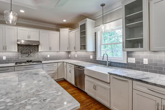 a spacious bathroom with a granite countertop sink a mirror and a shower
