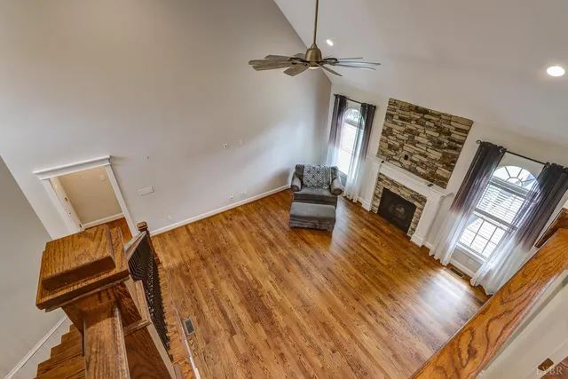 an aerial view of a residential houses with outdoor space and trees all around