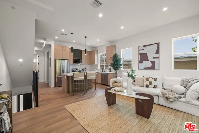 a kitchen with counter top space a sink wooden floor and a large window