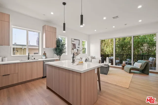 a kitchen with kitchen island a large counter top space appliances and a center island