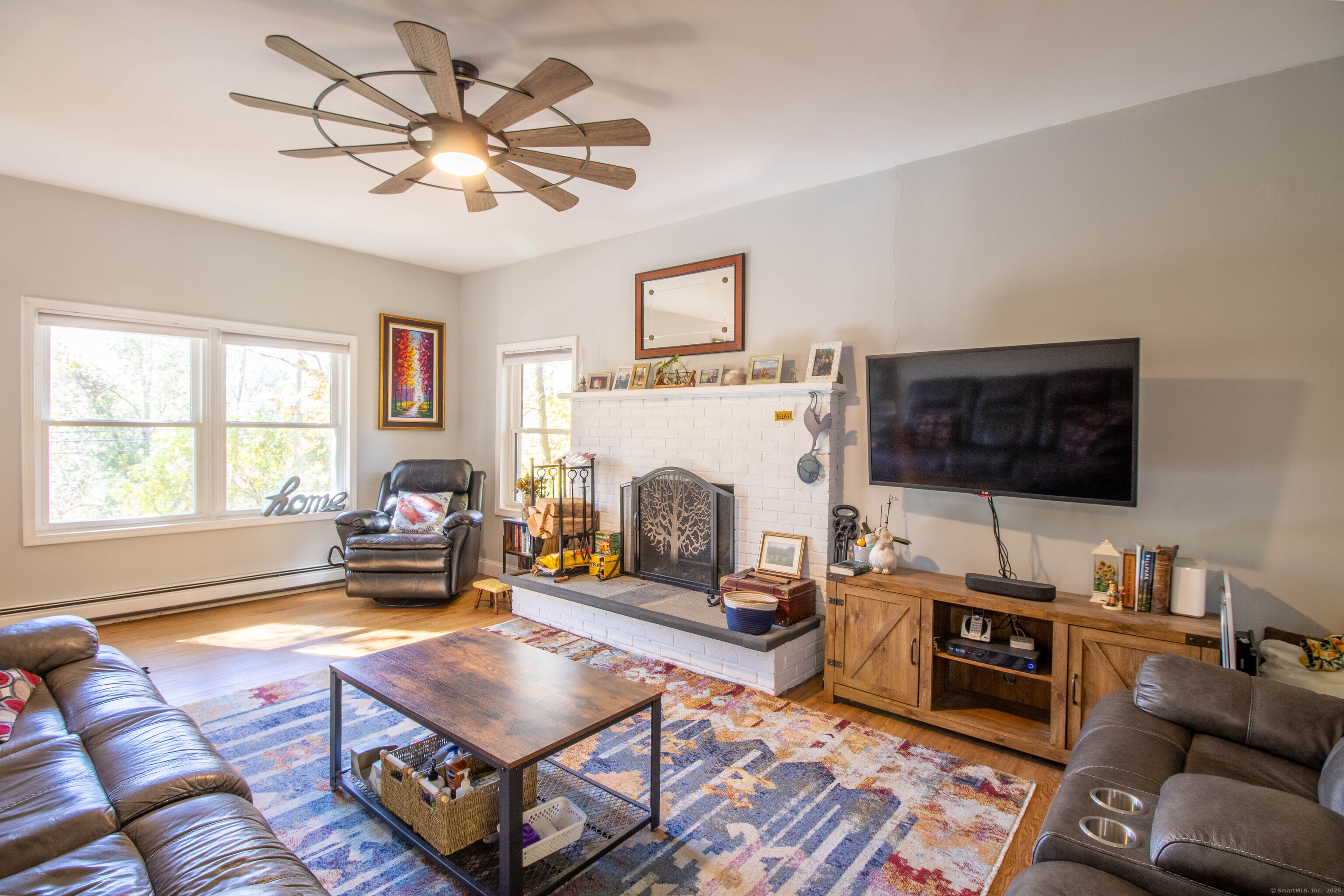 26 Firetown Road Simsbury, CT 06070 - Photo 28 of 40 a living room with furniture a flat screen tv and a fireplace