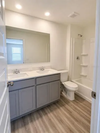 a bathroom with a double vanity sink toilet and shower