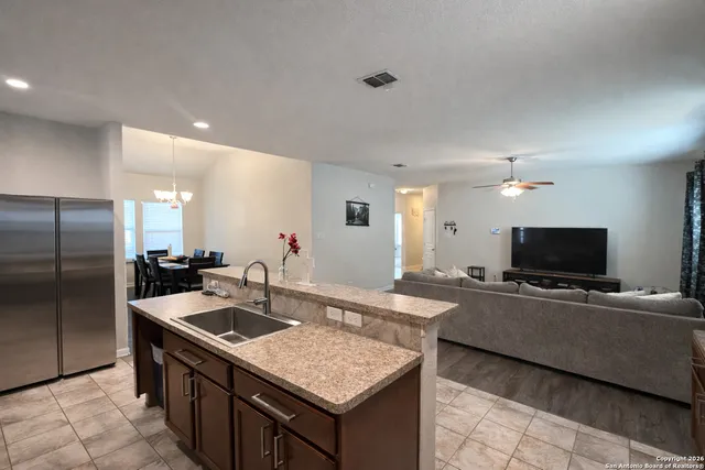 a kitchen with stainless steel appliances granite countertop a sink a stove and a refrigerator