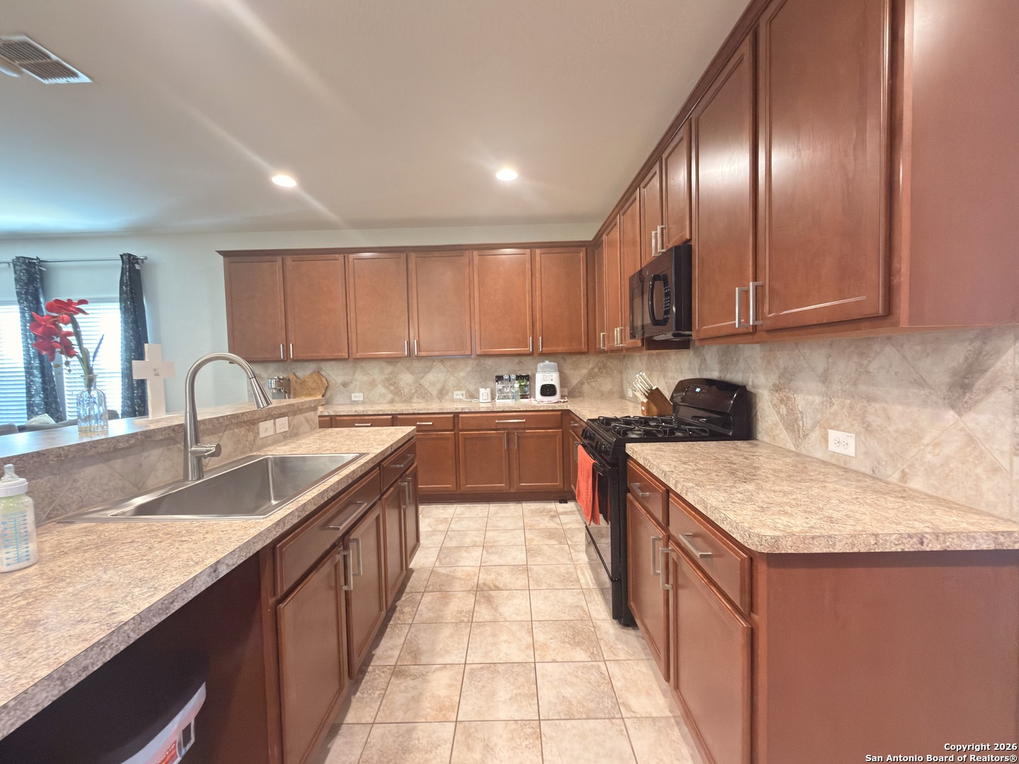 8949 Elizabeth Park Converse, TX 78109 - Photo 14 of 35 a kitchen with granite countertop a sink stove and cabinets