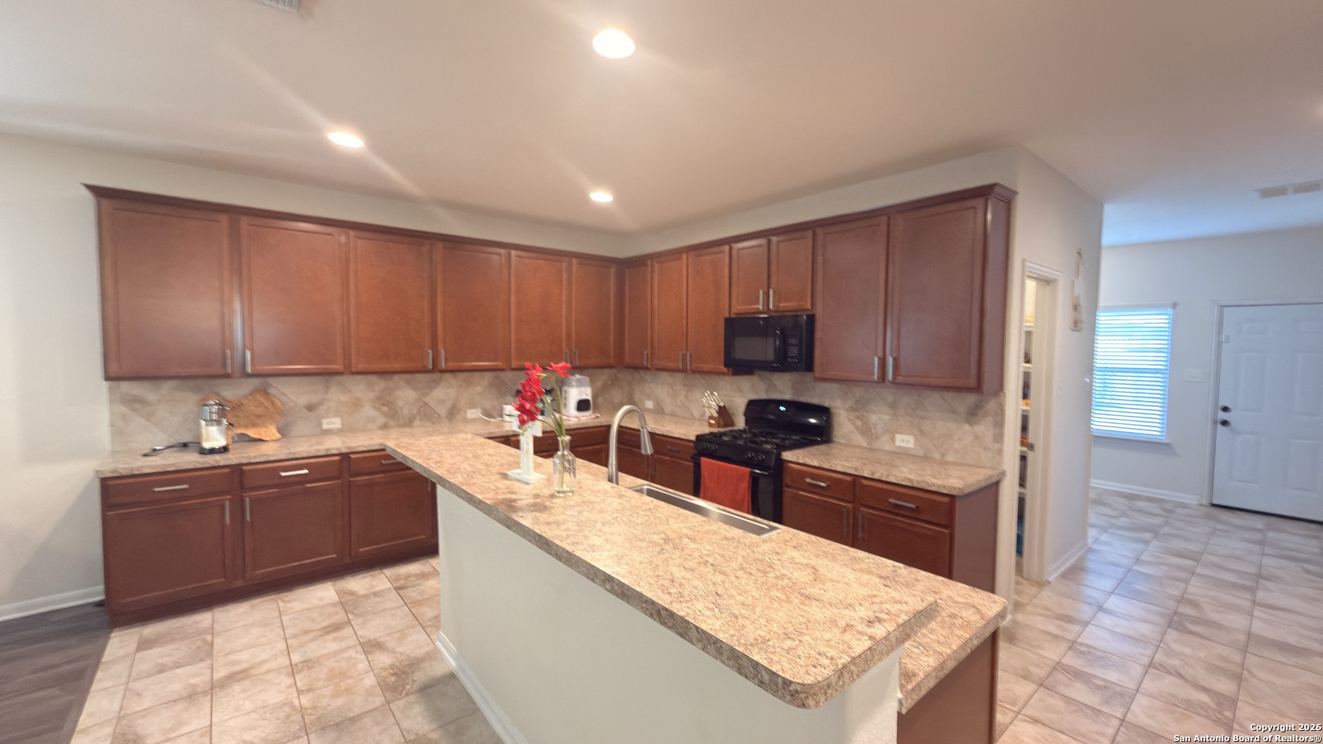 8949 Elizabeth Park Converse, TX 78109 - Photo 15 of 35 a kitchen with a sink a stove and a refrigerator