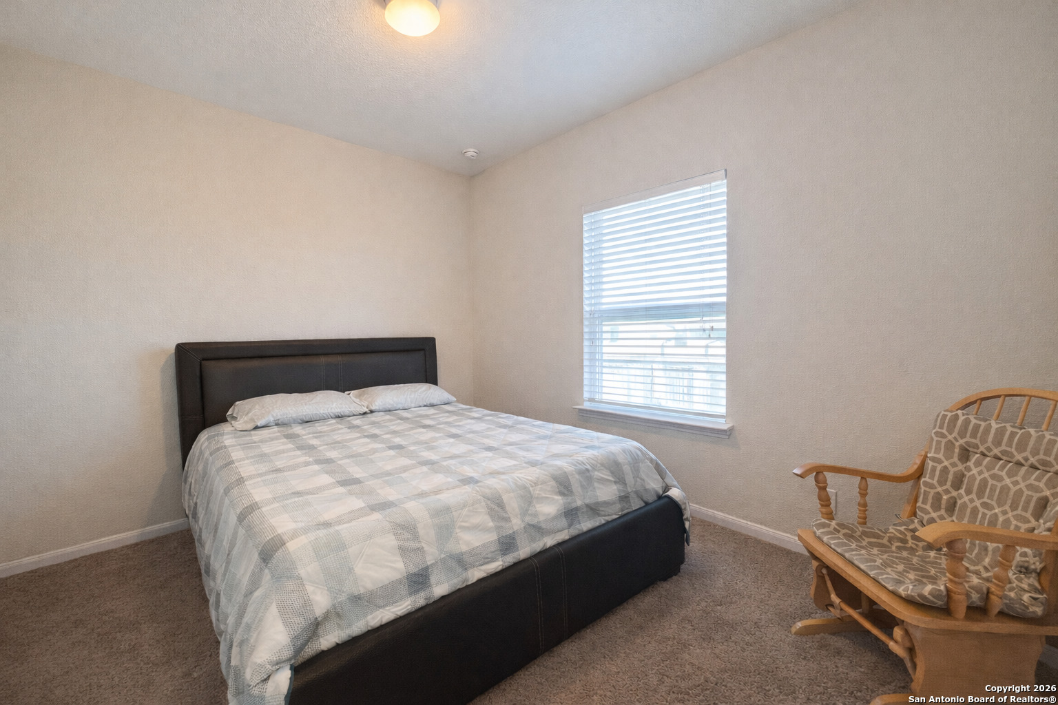 8949 Elizabeth Park Converse, TX 78109 - Photo 6 of 35 a large bed sitting in a bedroom next to a window