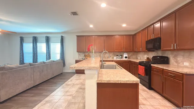 a large kitchen with kitchen island a sink a counter top space and appliances