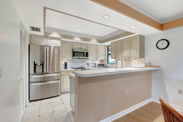 a kitchen with stainless steel appliances granite countertop a refrigerator and a sink