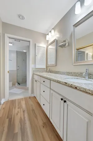 a bathroom with a granite countertop double vanity sink and mirror
