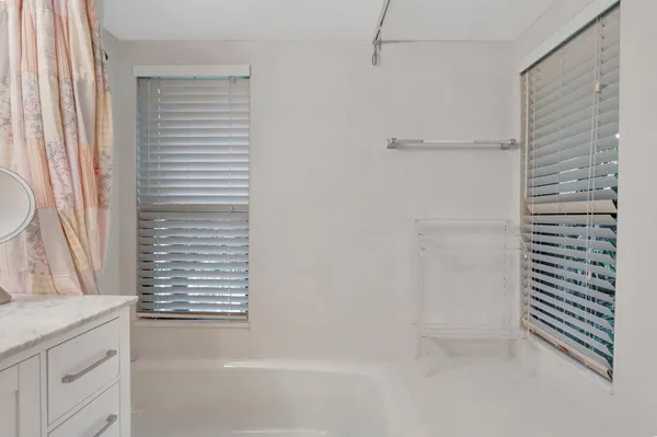 a bathroom with a granite countertop shower and a sink