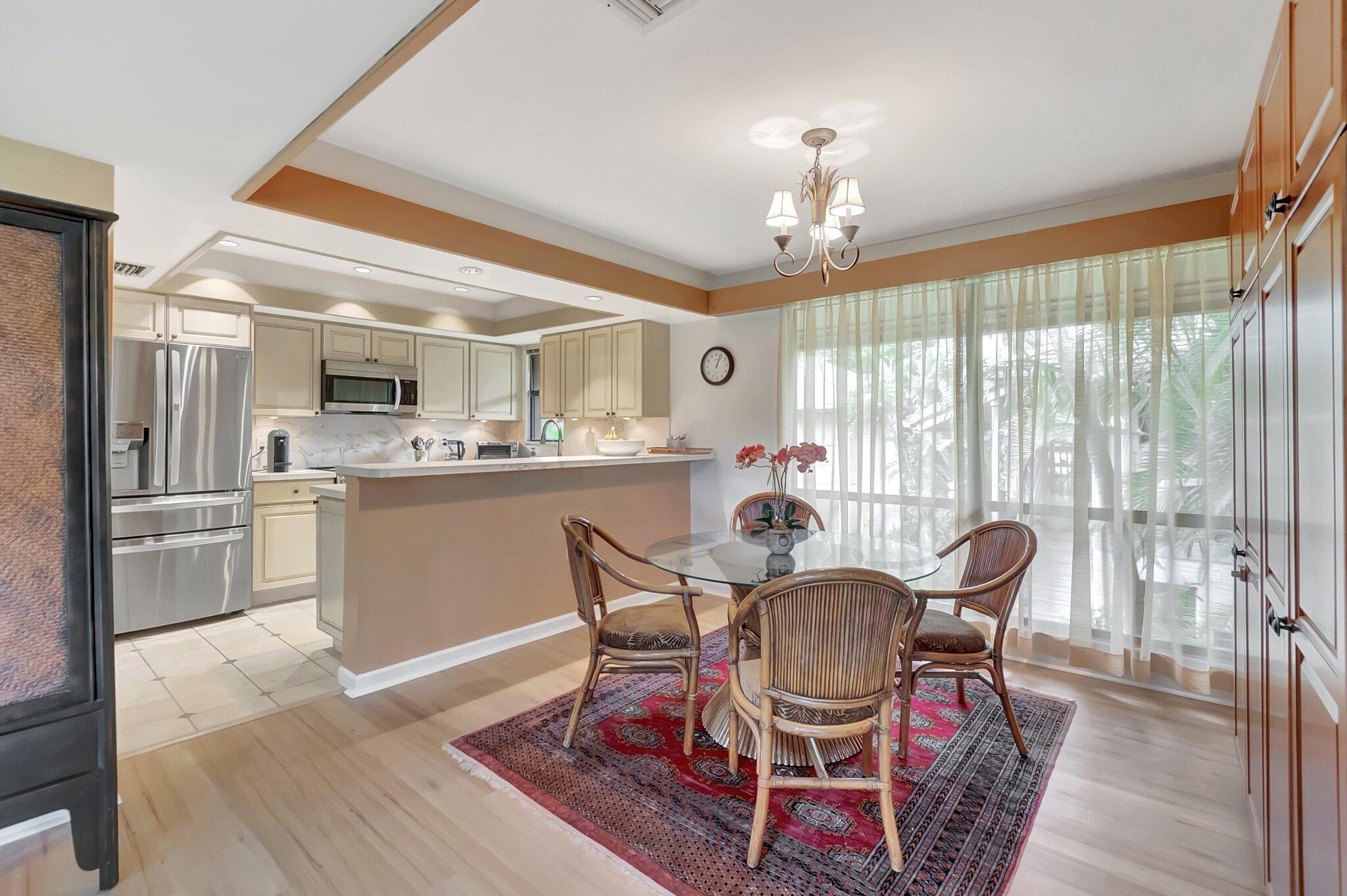 7067 Rain Forest Drive Boca Raton, FL 33434 - Photo 3 of 32 a dining room with furniture a chandelier and wooden floor