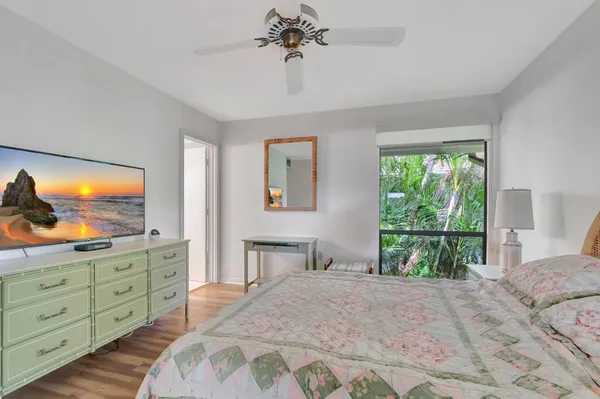 a bedroom with a bed and a flat tv screen on dresser