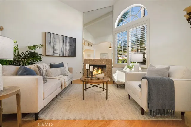 a living room with furniture a large window and a wooden floor