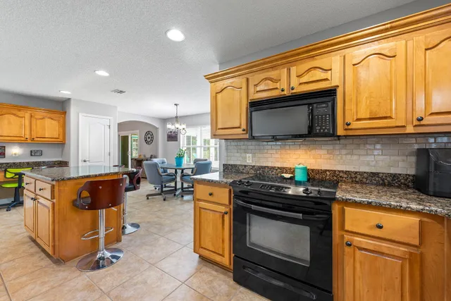 a dining room with furniture a chandelier and wooden floor