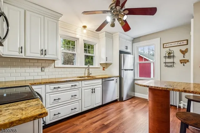 a kitchen with stainless steel appliances granite countertop a stove and white cabinets
