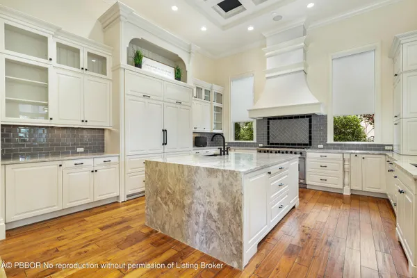 a large kitchen with stainless steel appliances granite countertop a stove and a white cabinets