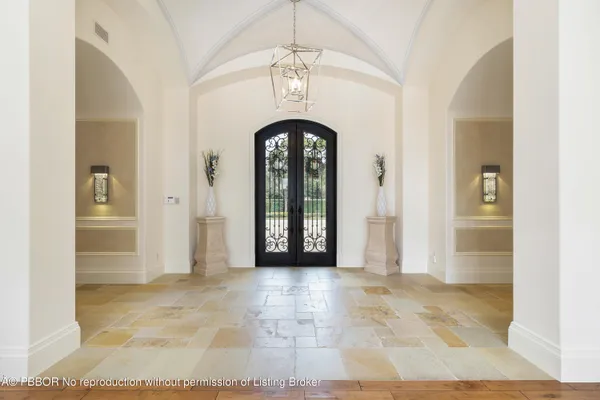 a view of a hallway with a chandelier and glass door