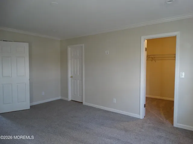an empty room with closet and a hallway