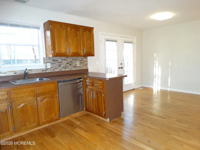 a kitchen with stainless steel appliances granite countertop a sink cabinets and wooden floor