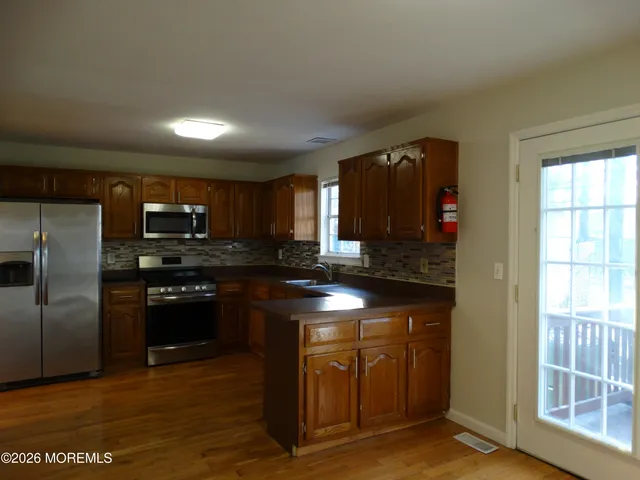 a kitchen with stainless steel appliances granite countertop a stove a sink and a refrigerator